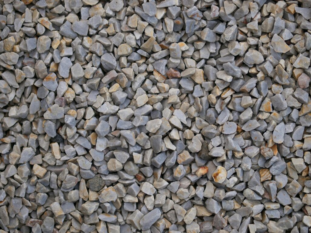 Detailed close-up texture of gravel stones outdoors in Normandie, perfect for backgrounds.